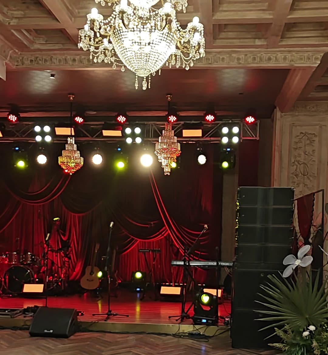 St. Regis Mumbai banquet hall — 38th floor stage with line array deployed and crystal chandeliers overhead