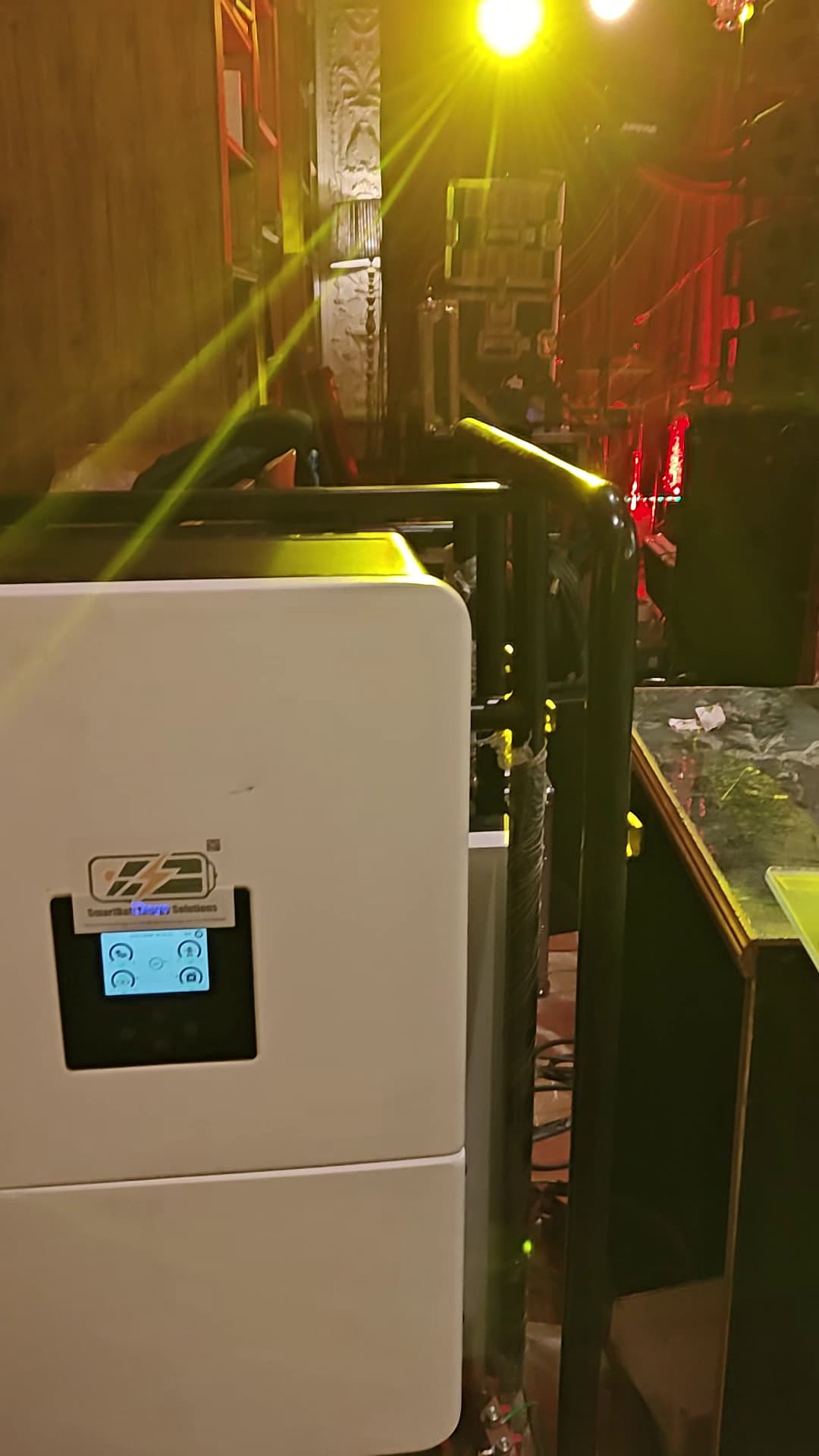 SmartBatt unit positioned behind the bar counter — display panel active, powering the sound system for 18 hours